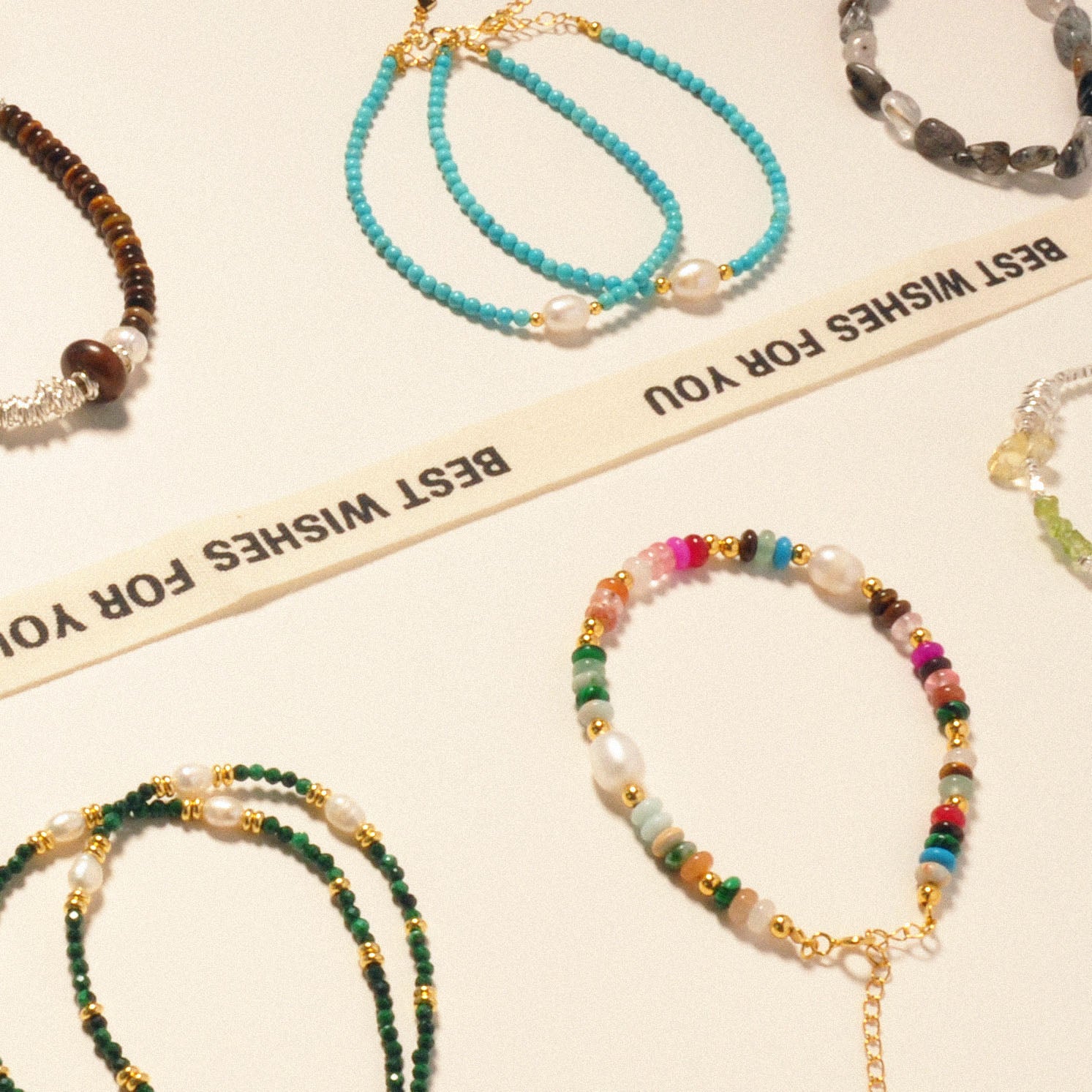 Mehrere Armbänder in verschiedenen Designs auf einem Tisch ausgestellt.