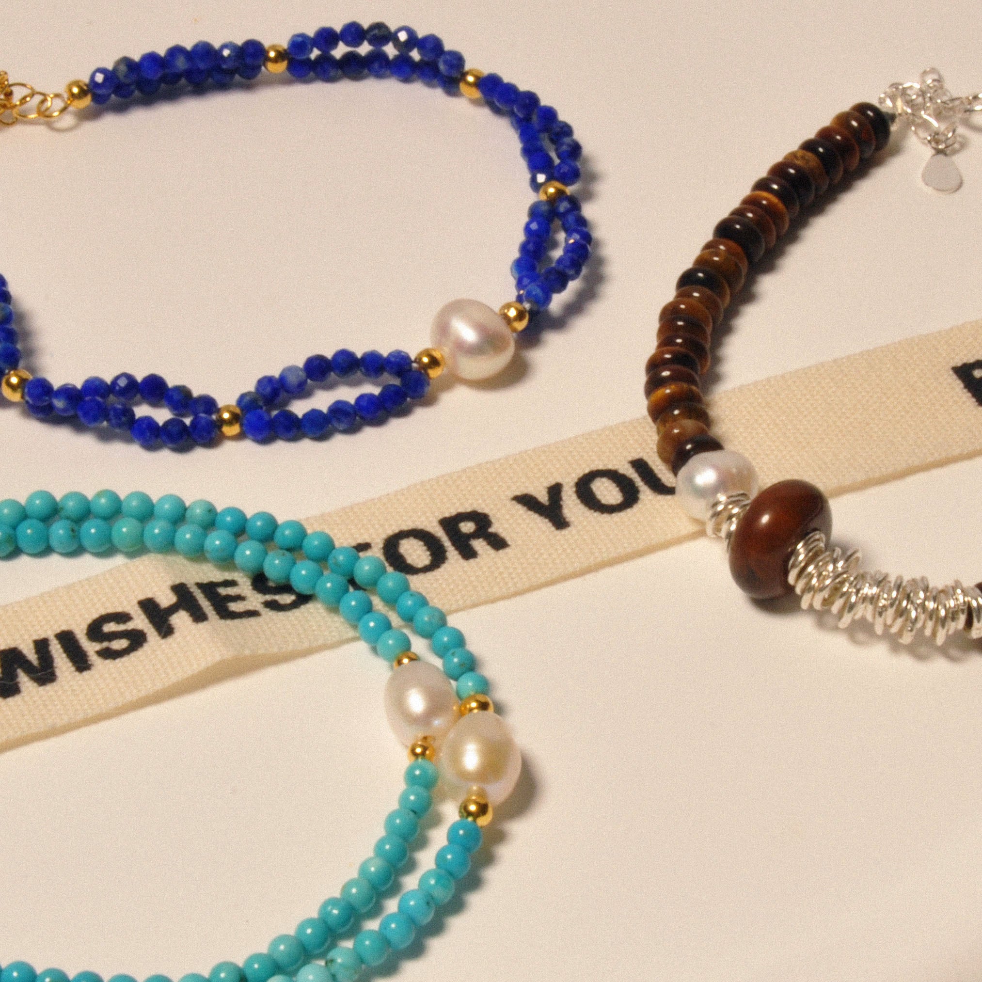 Mehrere Armbänder in verschiedenen Designs auf einem Tisch ausgestellt.