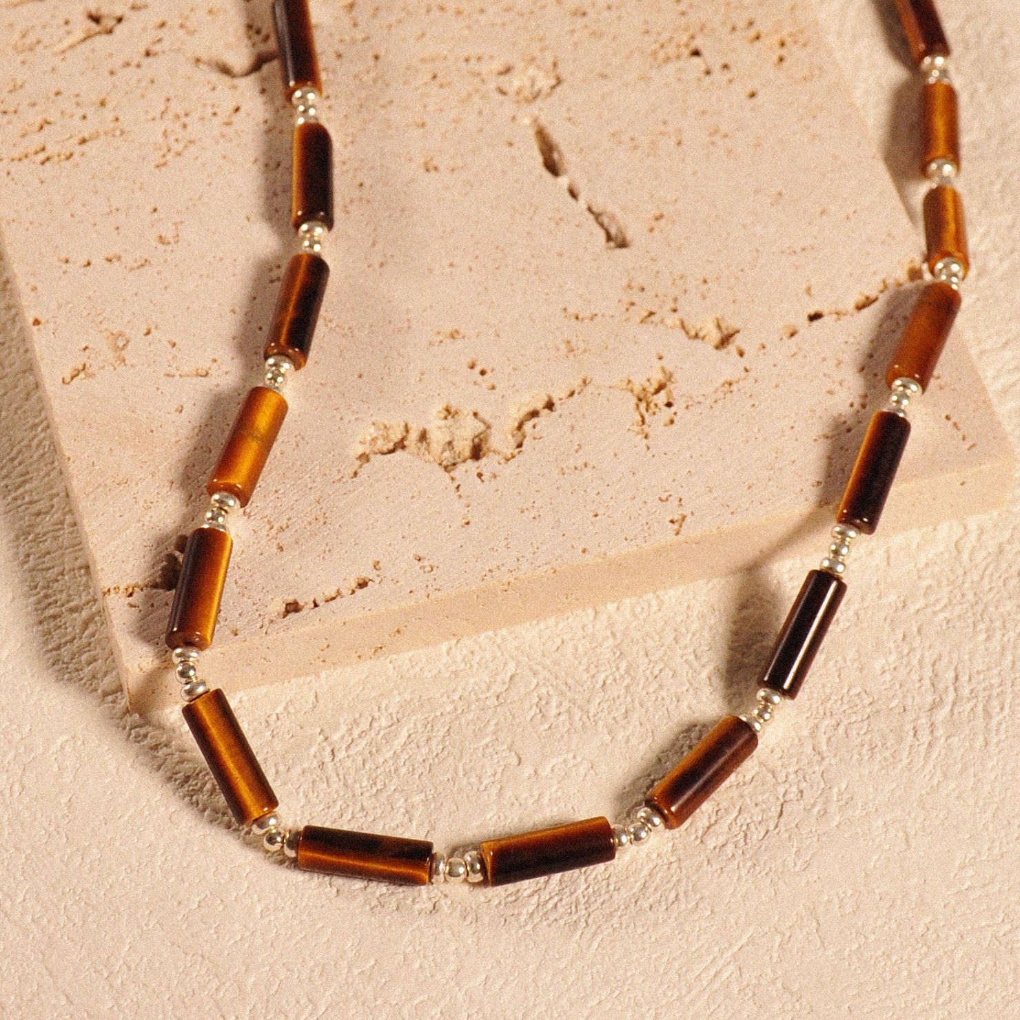 Nahaufnahme der Prosperity Halskette auf einem beige