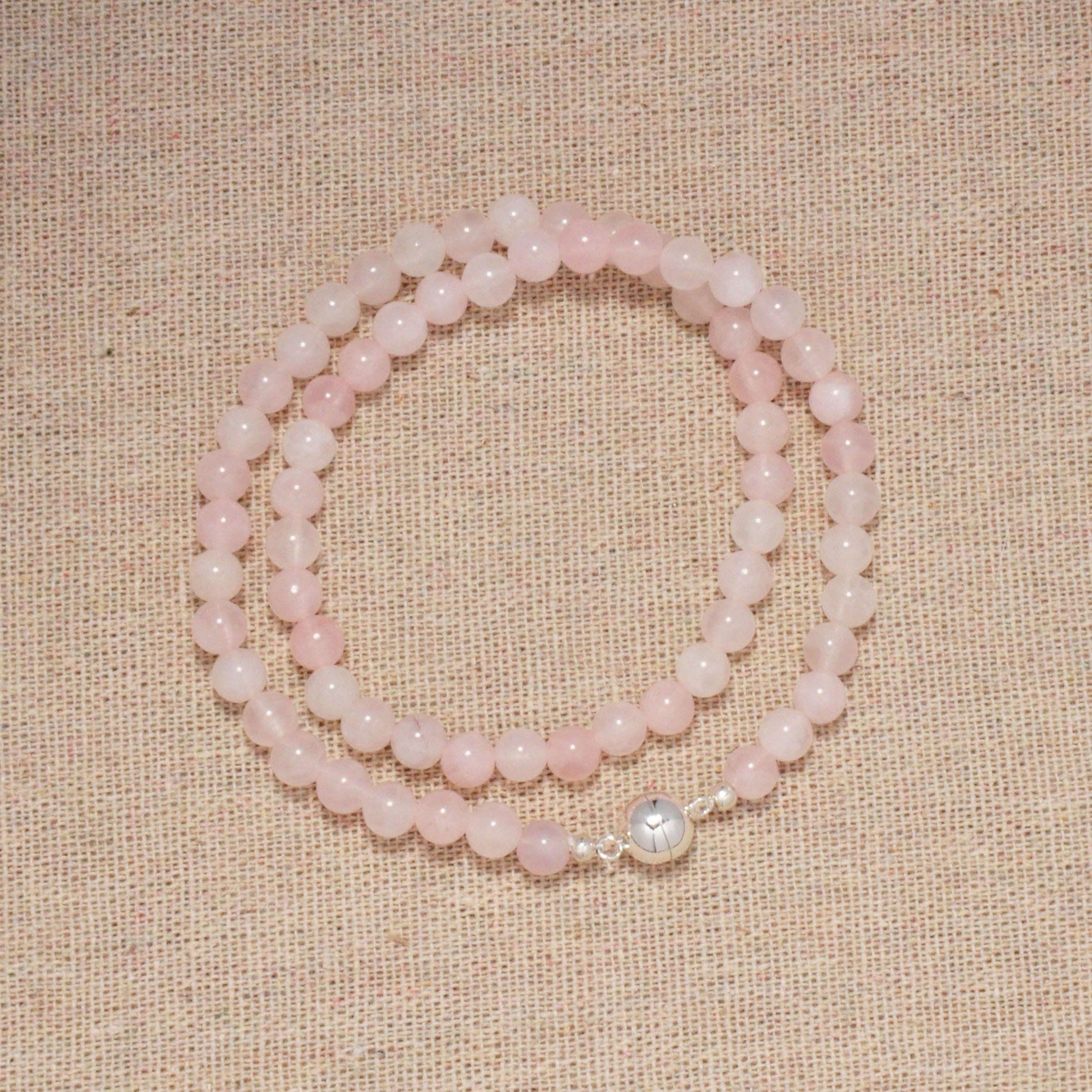 Rosenquarz Rose Garden Halskette auf einer weißen Oberfläche.