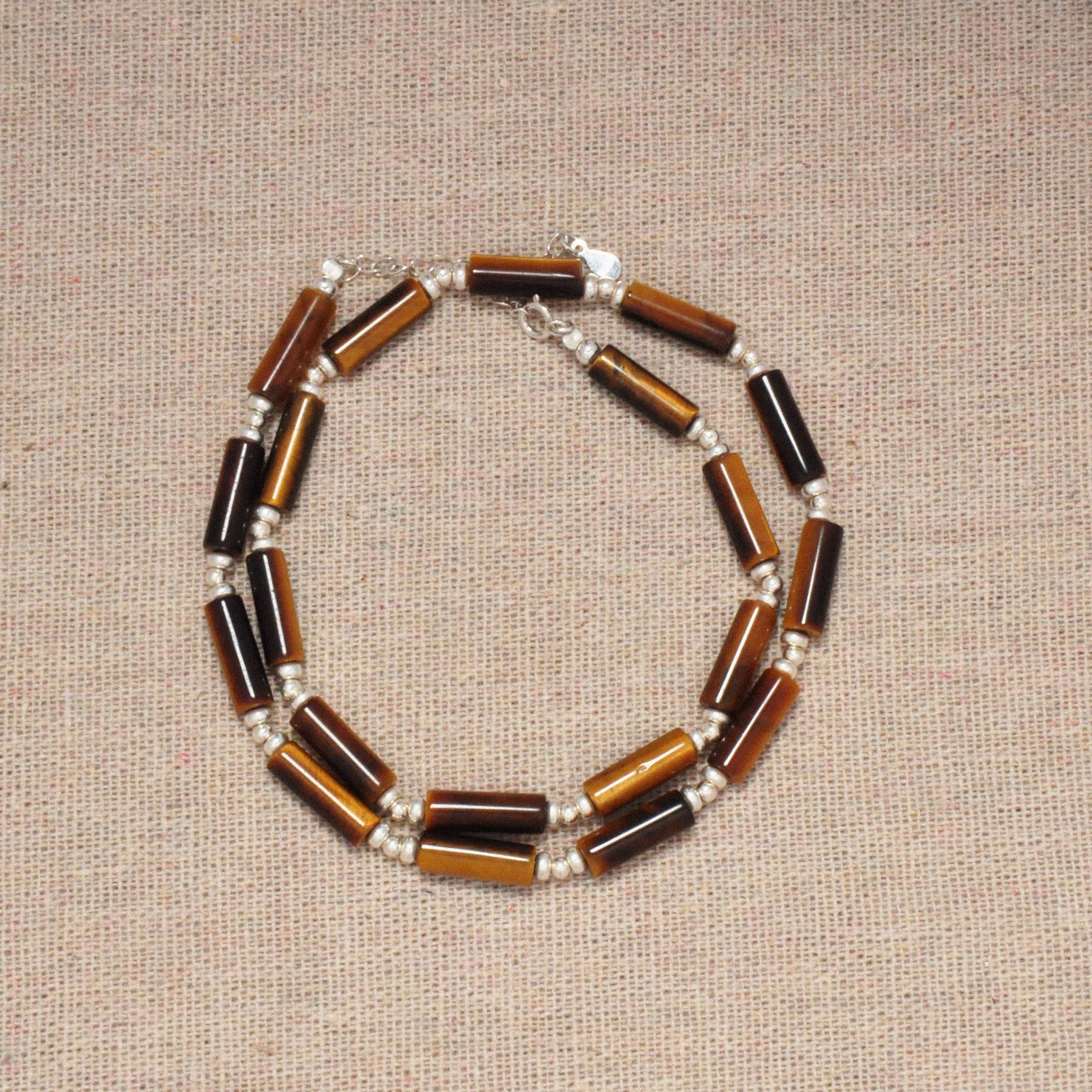 Nahaufnahme der Prosperity Halskette auf einem beige Hintergrund