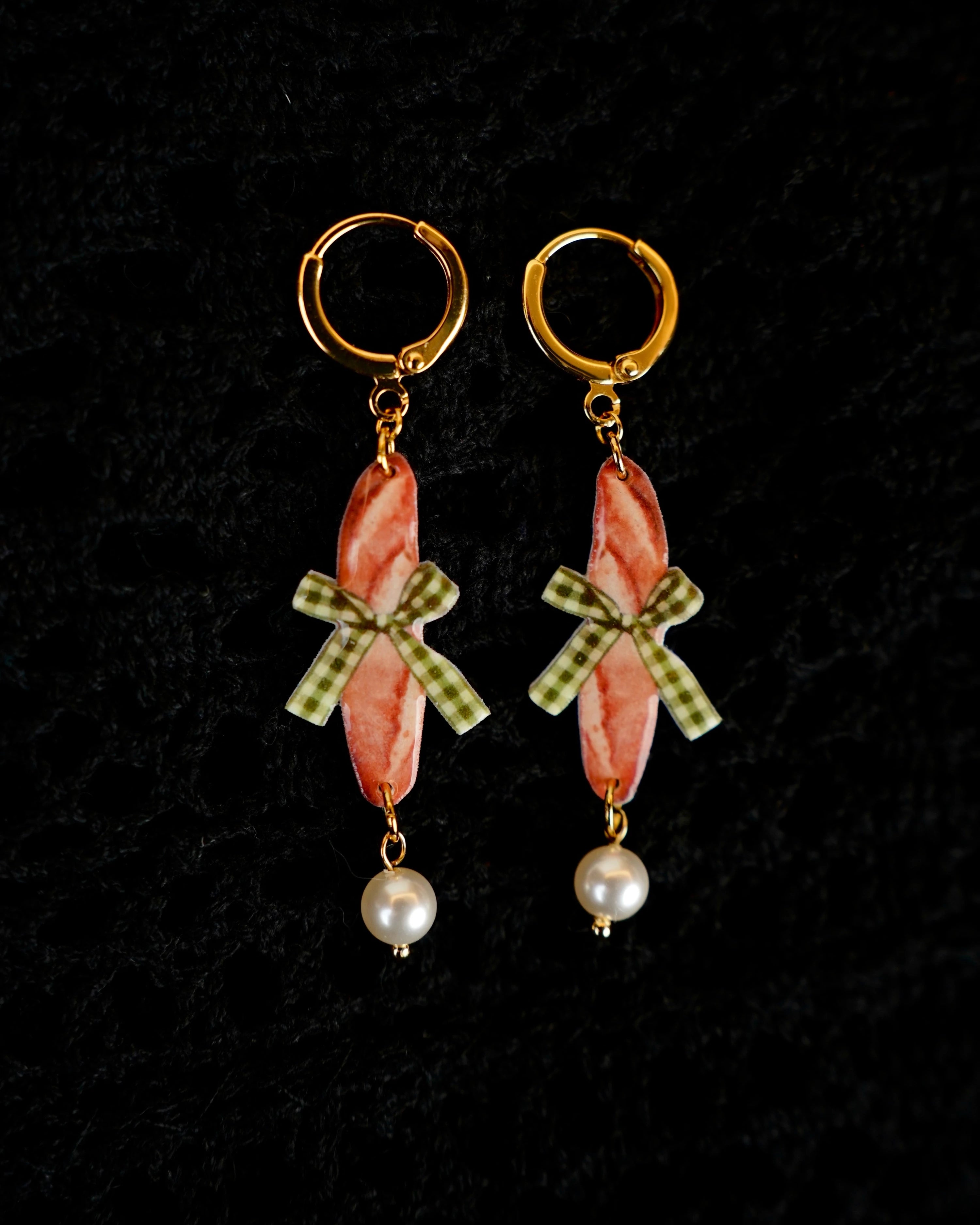 Detailaufnahme der Playful Drops Ohrringe mit Baguette-Design, grüner Schleife und goldenen Akzenten – auf schwarzem Hintergrund, handgefertigt in Hamburg.