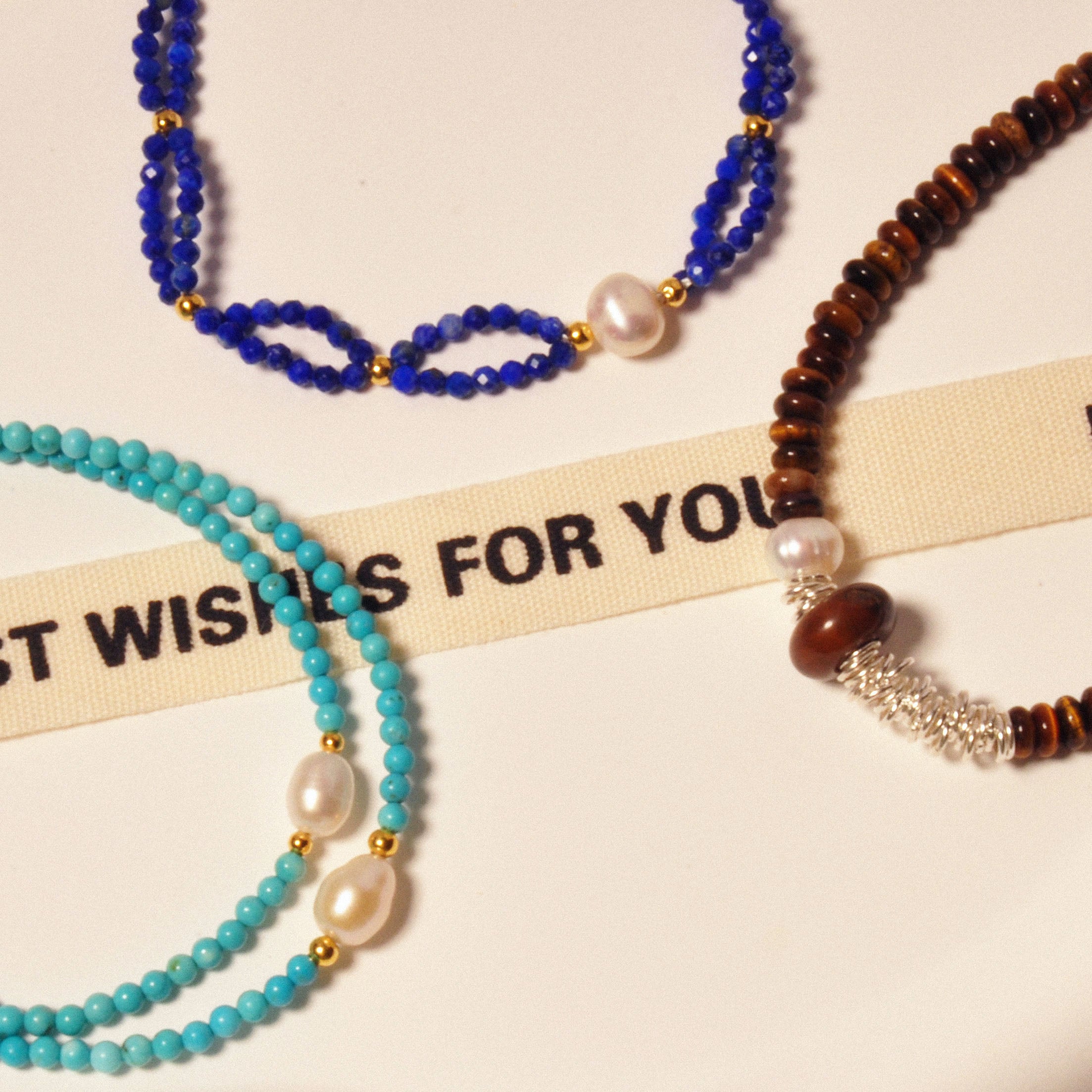 Mehrere Armbänder in verschiedenen Designs auf einem Tisch ausgestellt.