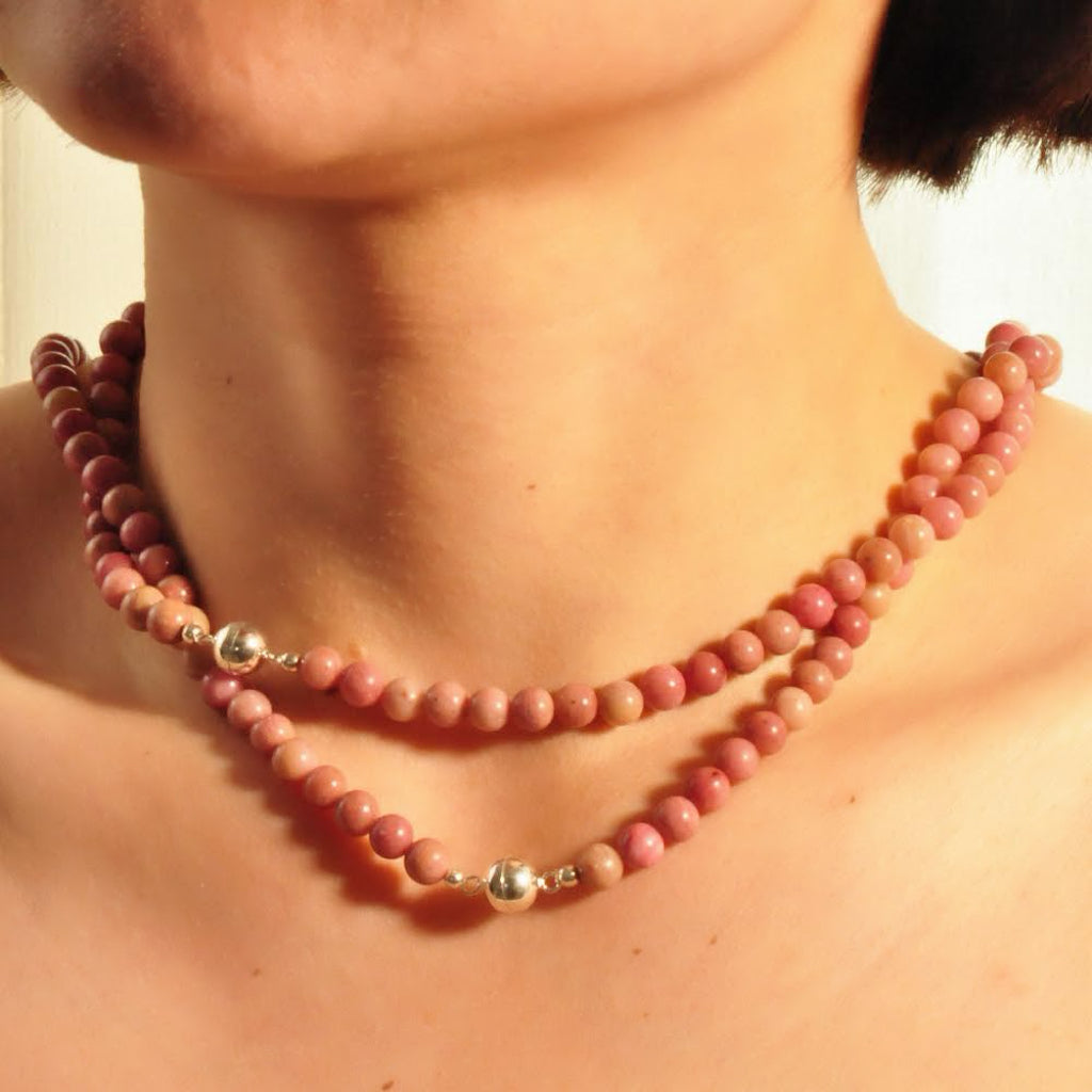 Modell trägt zwei Eros Halsketten, die zusammen einen eleganten Layering-Effekt erzeugen.