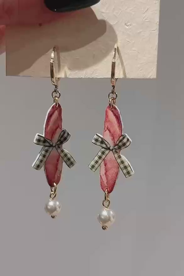 Kurzes Video zeigt die handgefertigten Playful Drops Ohrringe im natürlichen Licht – Baguette-Design mit grüner Schleife und Perle, Luumi Creative Hamburg.